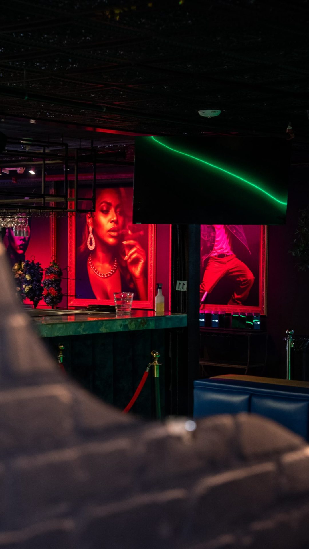 Neon-lit bar with red portrait art inside the Privilege lounge