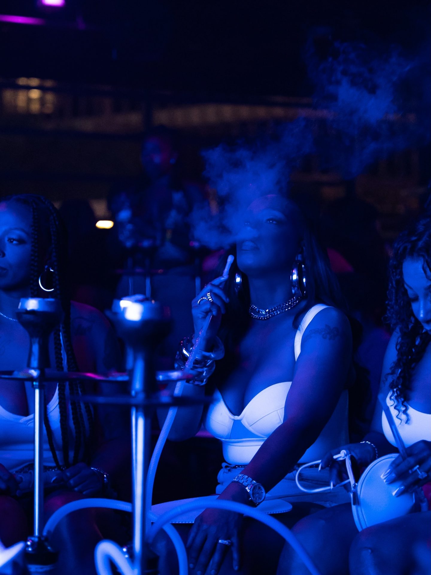Guests with hookah service in the blue-lit lounge